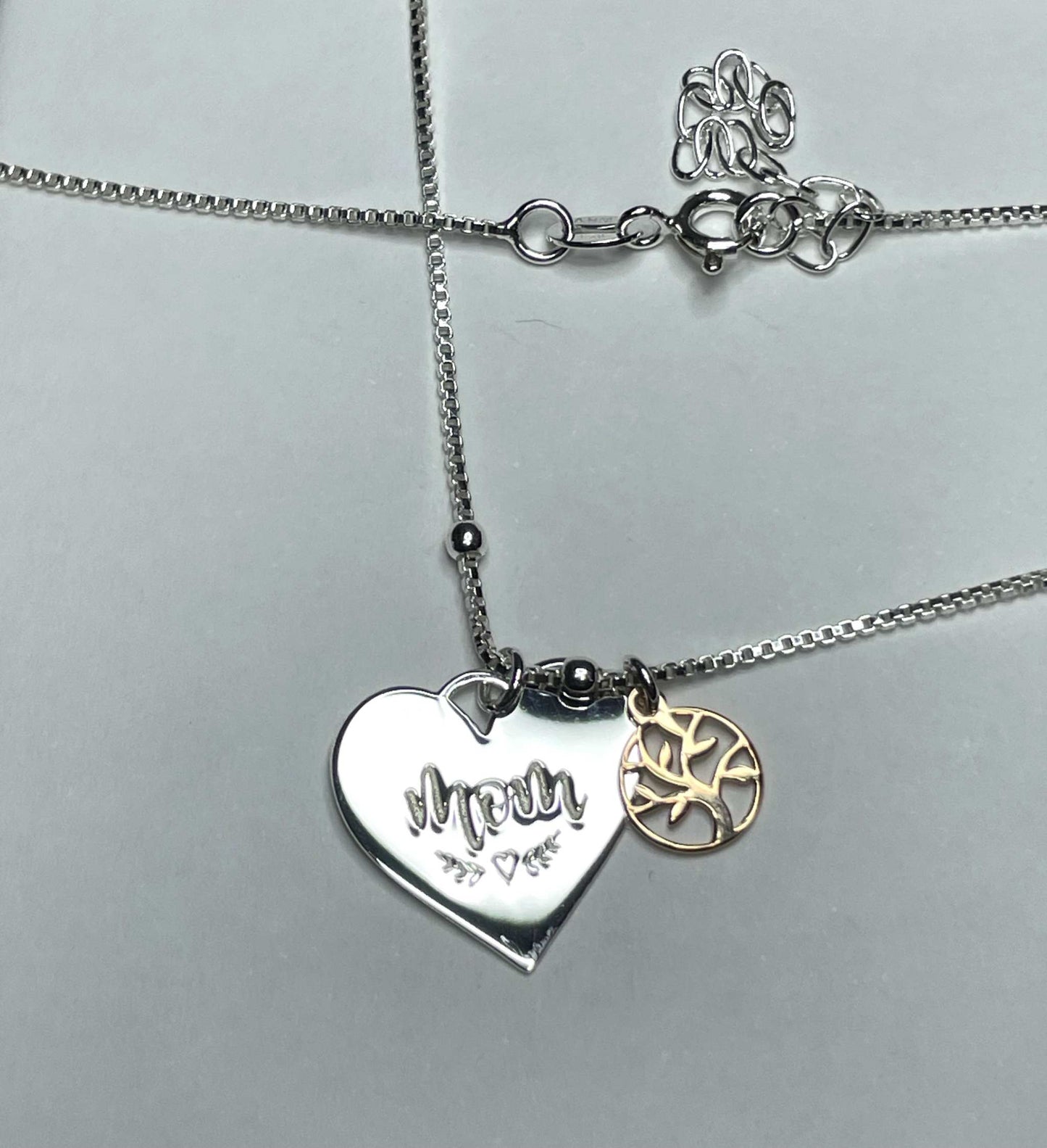 Sterling silver mom and family tree necklace with heart and vine detailing.